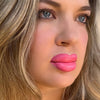 Close-up of a woman with pink lipstick and blonde hair. lip filler 
