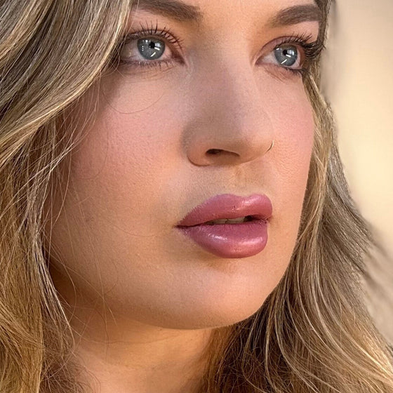 Close-up of a woman with blonde hair and blue eyes. lip filler. lip prosthetic