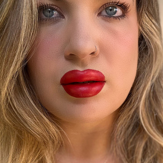Close-up of a person with red lipstick and blonde hair. lip filler. lip prosthetic