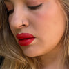 Close-up of a woman's face with red lipstick and blonde hair. lip filler. lip prosthetic