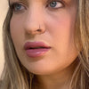 Close-up of a person with blonde hair and blue eyes. lip filler. lip prosthetic
