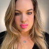 Woman with long blonde hair and pink lipstick wearing a black top. lip filler. lip prosthetic