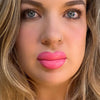 Close-up of a woman with pink lipstick and blonde hair. lip filler. lip prosthetic
