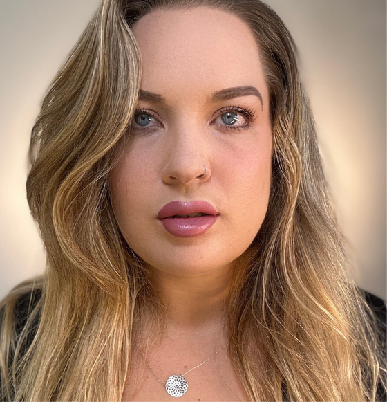 Close-up of a person with long blonde hair and a blurred background. lip filler. lip prosthetic