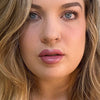 Close-up of a person with blonde hair and pink lipstick. lip filler. lip prosthetic
