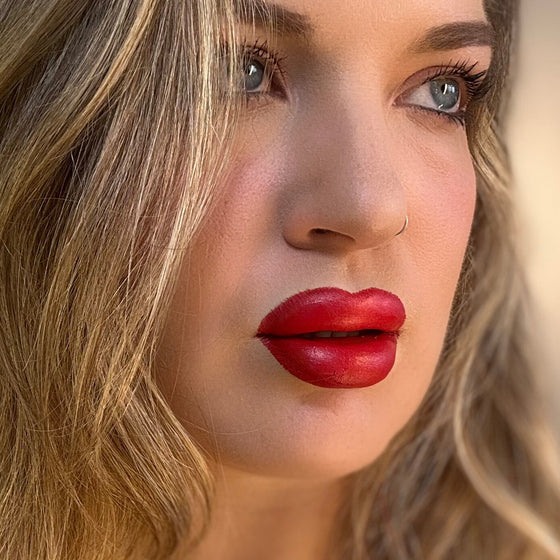 Close-up of a woman with red lipstick and blonde hair. lip filler. lip prosthetic